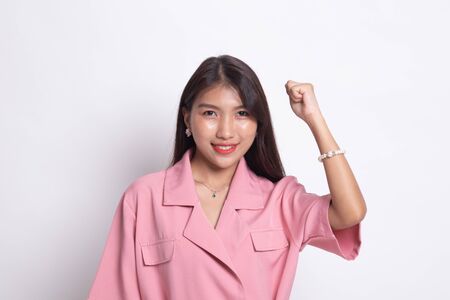 Successful  young Asian woman hold fist up on white background.の写真素材