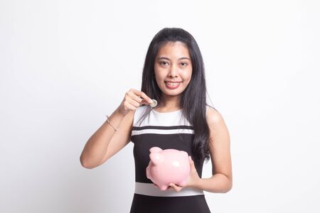 Asian woman with coin and pig coin bank on white backgroundの写真素材