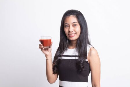 Young Asian woman drink tomato juice on white backgroundの写真素材
