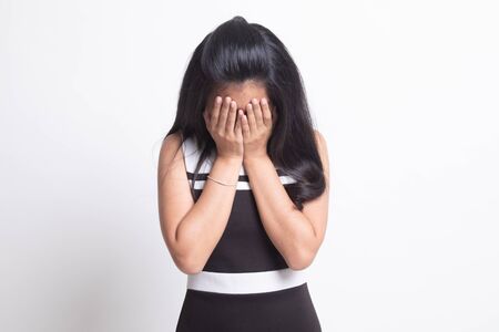 Sad young Asian woman cry with palm to face on white backgroundの写真素材