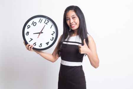 Young Asian woman thumbs up with a clock on white backgroundの写真素材