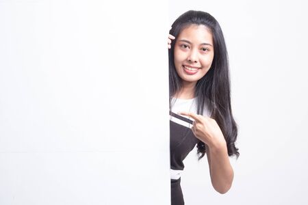 Young Asian woman point to a  blank sign on white backgroundの写真素材