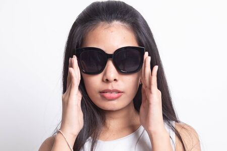 Portrait of a beautiful young asian girl in sunglasses on white backgroundの写真素材
