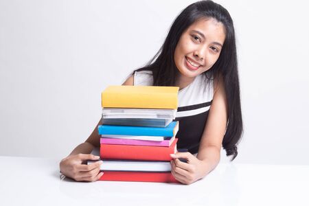 Happy young Asian woman read a book with books on table on white backgroundの写真素材