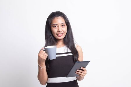 Young Asian woman with a computer tablet and coffee on white backgroundの写真素材