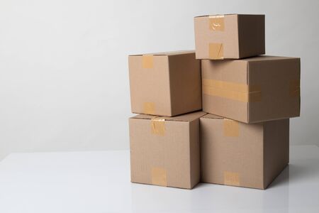 Pile of various size taped up  cardboard boxes on white background
