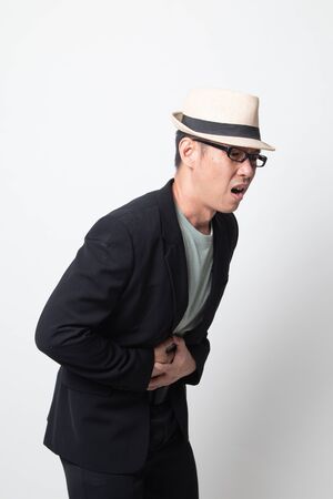 adult asian man got stomachache on white backgroundの写真素材