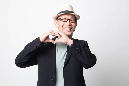 adult asian man  show heart hand sign on white backgroundの写真素材