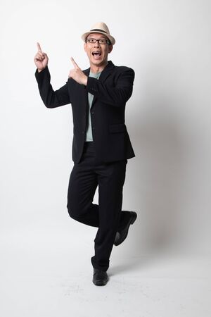 Full body of an adult asian man pointing up on white backgroundの写真素材