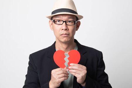 adult asian man with broken heart on white backgroundの写真素材