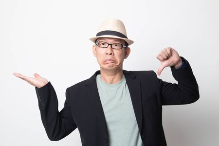 adult asian man show palm hand and thumbs down on white backgroundの写真素材