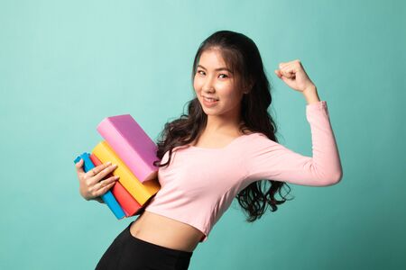 Young Asian woman studying  with may books on cyan backgroundの写真素材