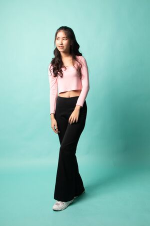 Full body of beautiful young asian woman on cyan backgroundの写真素材