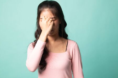 Young Asian woman got sick and  headache on cyan backgroundの写真素材