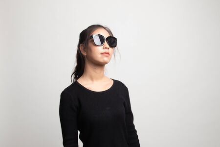 Portrait of a beautiful young asian girl in sunglasses on white backgroundの写真素材