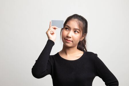 Young Asian woman think with a blank card on white backgroundの写真素材