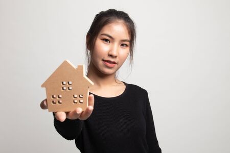 Happy young asian woman with house model on white backgroundの写真素材