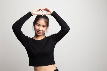 Young Asian woman gesturing heart hand sign on white backgroundの写真素材