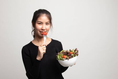 Healthy Asian woman with salad on white backgroundの写真素材
