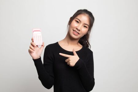 Asian woman point to  calculator on white backgroundの写真素材
