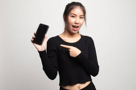 Excited Young Asian woman point to mobile phone on white backgroundの写真素材