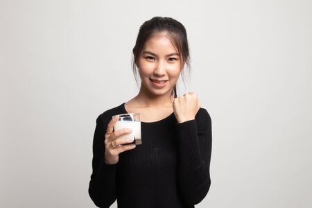 Healthy Asian woman drinking a glass of milk on white backgroundの写真素材
