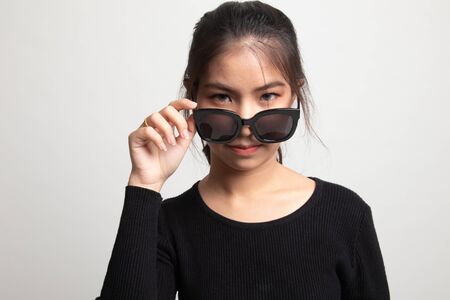 Portrait of a beautiful young asian girl in sunglasses on white backgroundの写真素材