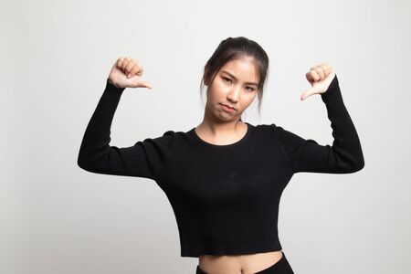 Unhappy Asian girl show thumbs down with both hands on white backgroundの写真素材