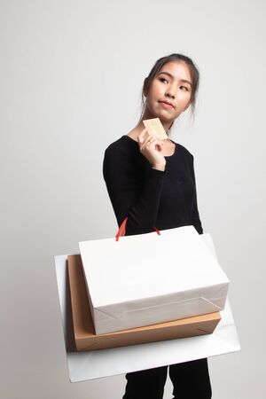 Young Asian woman with shopping bag and blank card on white backgroundの写真素材