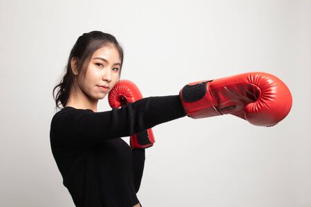 Young Asian woman with red boxing gloves on white backgroundの写真素材
