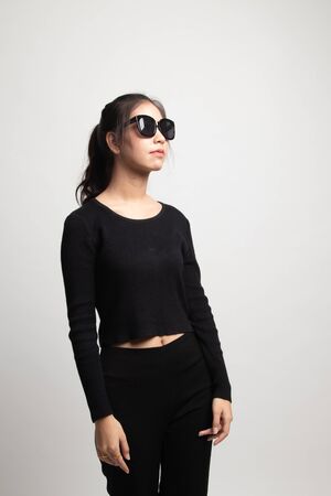 Portrait of a beautiful young asian girl in sunglasses on white backgroundの写真素材