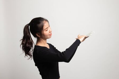 Portrait of very happy  young asian woman throwing out money banknotes on white backgroundの写真素材