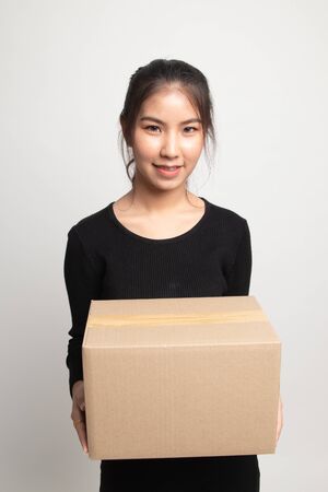 Delivery, relocation and unpacking.  young asian woman holding cardboard box on white backgroundの写真素材