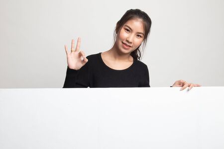 Young Asian woman show OK with blank sign on white backgroundの写真素材