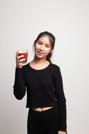Young Asian woman drink tomato juice on white backgroundの写真素材