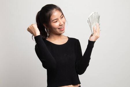 Portrait of  young asian woman  showing bunch of money banknotes on white backgroundの写真素材
