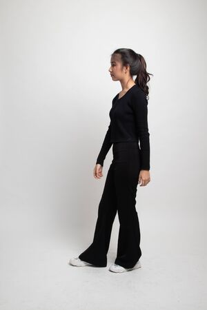 Full body of beautiful young asian woman walking on white backgroundの写真素材