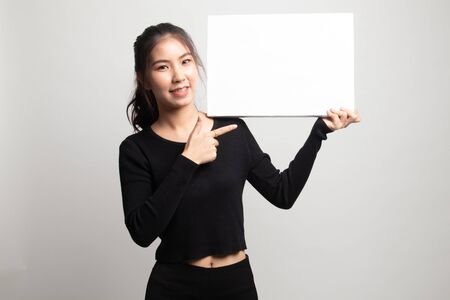 Young Asian woman point to  blank sign on white backgroundの写真素材
