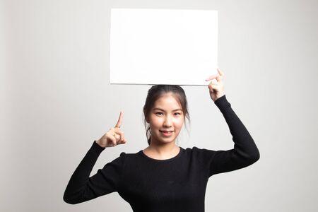 Young Asian woman point to blank sign on white backgroundの写真素材