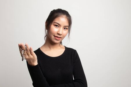 Cute asian girl showing home residence keys on white backgroundの写真素材