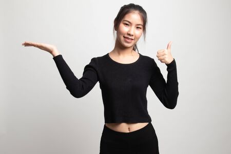 Beautiful young Asian woman show palm hand and thumbs up on white backgroundの写真素材