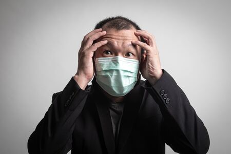 Sick Asian man  wearing surgical  mask to prevent flu virus and  PM2.5 dust air pollution on white backgroundの写真素材