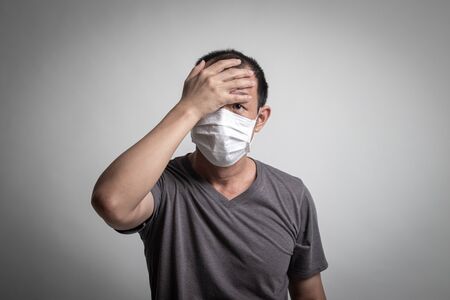 Sick Asian man coughing and  wearingsurgical  mask  to prevent flu virus and  PM2.5 dust air pollution on white backgroundの写真素材