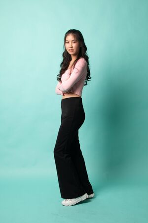 Full body of beautiful young asian woman on cyan backgroundの写真素材