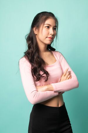 Portrait of beautiful young Asian woman on cyan backgroundの写真素材