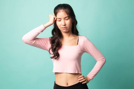 Young Asian woman got sick and  headache on cyan backgroundの写真素材