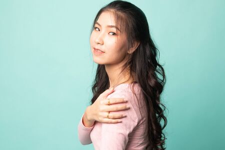 Happy Beautiful young Asian woman on cyan backgroundの写真素材