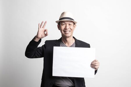 Adult Asian man  show OK with white blank sign on white backgroundの写真素材
