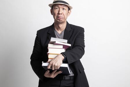 Unhappy adult Asian man  studying  with may books on white backgroundの写真素材