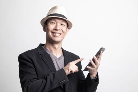 Adult Asian man  with a computer tablet on white backgroundの写真素材